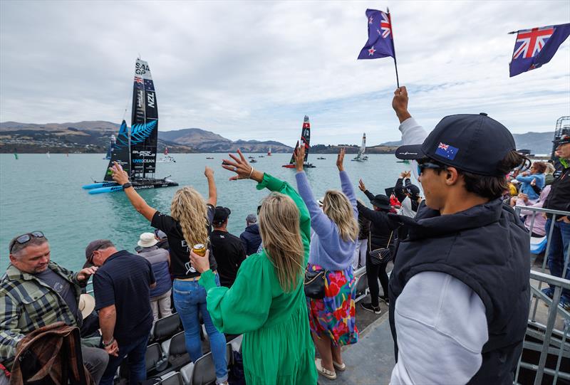 Spectators in the grandstand cheering the New Zealand SailGP Team as they wait on the water whilst the racing is on hold due to a dolphin sighting on the course on Race Day 1 of the ITM New Zealand Sail Grand Prix in Christchurch. March 23, 2024 photo copyright Brett Phibbs/SailGP taken at Naval Point Club Lyttelton and featuring the F50 class