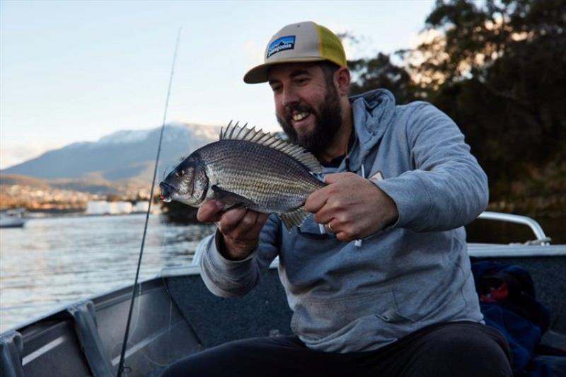 Success! A tough grind in cold conditions but perseverance paid off. Phil landing this nice bream.  - photo © Spot On Fishing Hobart