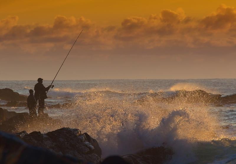 Father and son fishing at sunrise photo copyright Getty Images taken at 