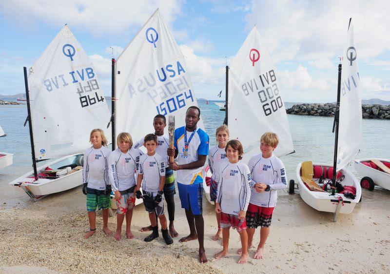 Thad Lettsome (left side of baton); Glenford Gordon (holding baton) and local optimist sailors with the Queen's Baton at the 2014 BVI Spring Regatta and Sailing Festival photo copyright Todd vanSickle / BVI Spring Regatta taken at Royal BVI Yacht Club and featuring the Optimist class