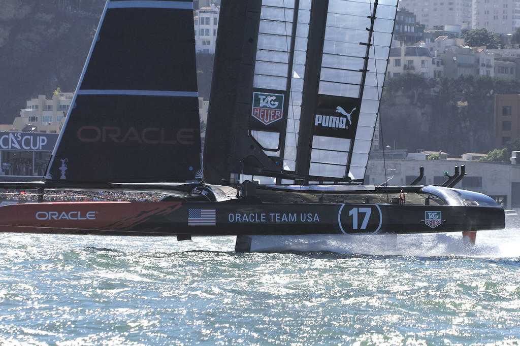 Looking like a crewless ghost ship, Oracle crosses the line at the race two finish, now four races behind ETNZ - America’s Cup © Chuck Lantz http://www.ChuckLantz.com
