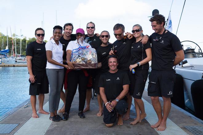 Overall winners and first recipients of the RORC Transatlantic Race Trophy as well as the IMA Trophy for Line Honours: Lupa of London's crew enjoy a warm Grenadian welcome and a huge basket of local goodies on arrival - 2014 RORC Transatlantic Race. © RORC/Arthur Daniel and Orlando K Romain