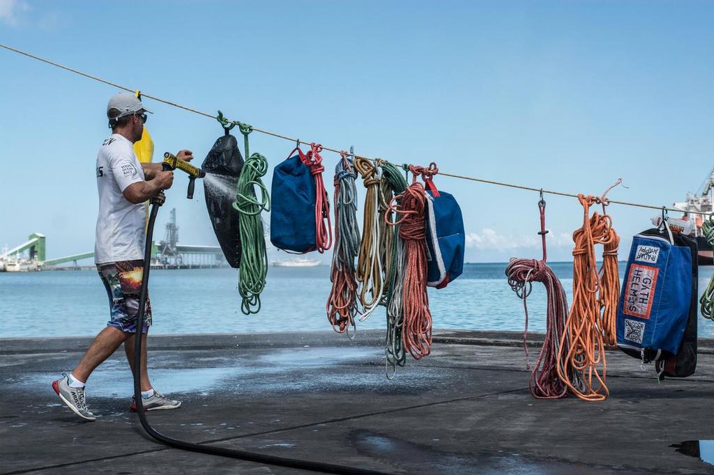December 03, 2014. Team Vestas Wind crew arrives to Mauritius with all the equipment they rescued from the boat after grounding on the Cargados Carajos Shoals on the 29th November; The crew are safe and uninjured but had to abandon the ship after it sustained damage to the stern. In this image Chris Nicholson cleaning the equipment. photo copyright  Marc Bow / Volvo Ocean Race taken at  and featuring the  class