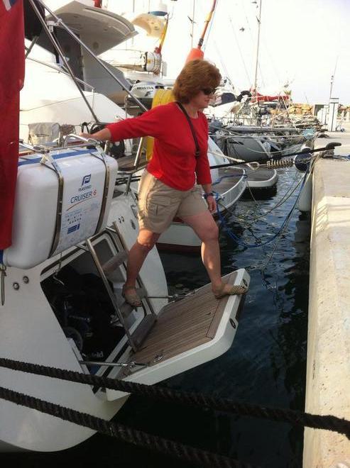 Sheryl stepping ashore using the transom door-swim platform as a passerelle. When moored stern-to on our Southerly 49, Distant Shores II, we can lower the transom door and use it as a boarding ramp in most situations. © Paul Shard