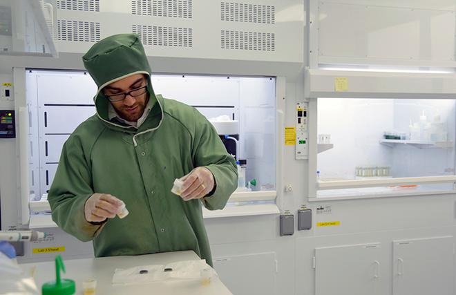 Adam Sarafian, lead author of the paper and a MIT - WHOI Joint Program student in the WHOI Geology and Geophysics Department, preps samples in Sune Nielsen's NIRVANA clean lab to remove all contamination from the surface prior to analysis. © Jayne Doucette, WHOI