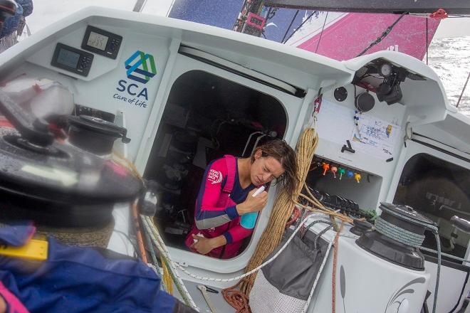 October, 2014. Leg 1 onboard Team SCA: Justine Mettraux rinses her face after her watch - Volvo Ocean Race 2014-15. © Corinna Halloran / Team SCA