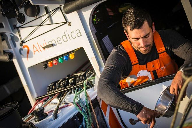 October, 2014. Leg one onboard Team Alvimedica. Day eight. Day of the Cape Verdes transit and decision time for the Equator - Doldrums approach. Mark Towill cleans his breakfast dish in the ocean water on the deck - Volvo Ocean Race 2014-15. ©  Amory Ross / Team Alvimedica