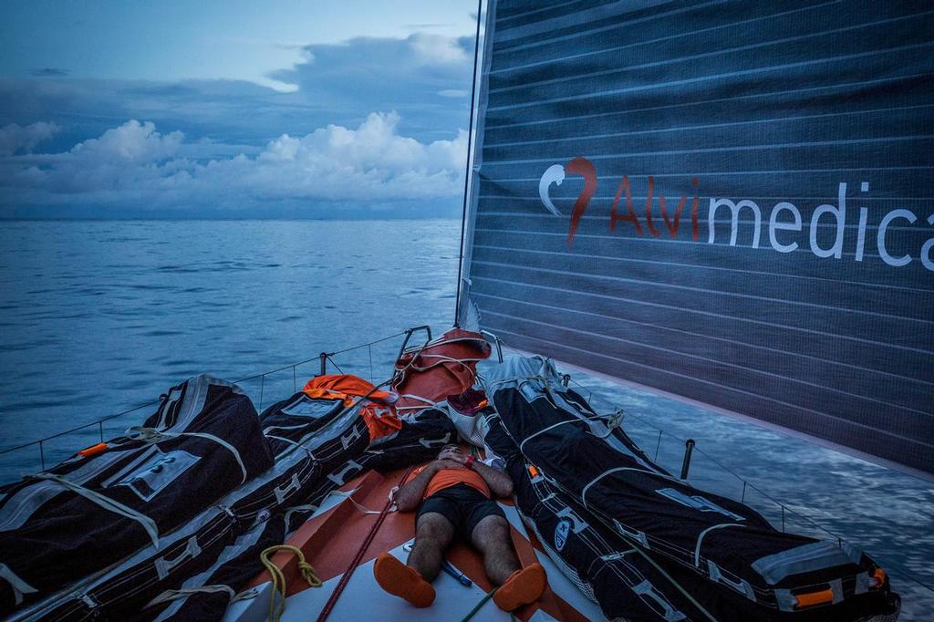 October 22, 2014. Leg 1 onboard Team Alvimedica. Day 11. The third day in the clutches of the Doldrums brings no breaks for Team Alvimedica, still searching for consistent winds and a way south with the fleet. Charlie Enright grabs a quick nap on the bow in the doldrums, where sleep can be hard go find with always-changing weather. ©  Amory Ross / Team Alvimedica