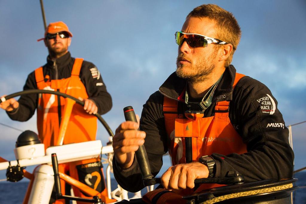 Volvo Ocean Race - October 28, 2014. Leg 1 onboard Team Alvimedica. Day 18. The fleet begins the gradual turn east around the South Atlantic High, a final few days of calm before rocketing to Cape Town. Nick Dana trims the traveler at sunrise of Day 18 after a much cooler night heading south. photo copyright  Amory Ross / Team Alvimedica taken at  and featuring the  class