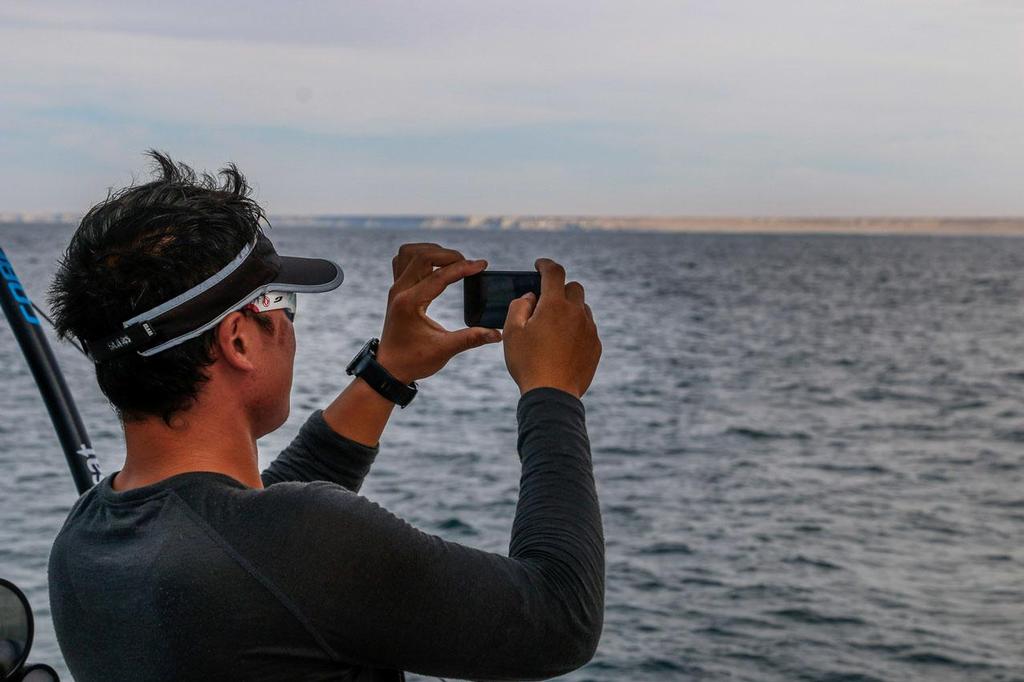2014-15 Volvo Ocean Race - October 16, 2014. Leg 1 onboard Dongfeng Race Team. Jin Hao Chen, aka Horace, taking a photograph of Africa ``The first time I see Africa`` photo copyright Yann Riou / Dongfeng Race Team taken at  and featuring the  class