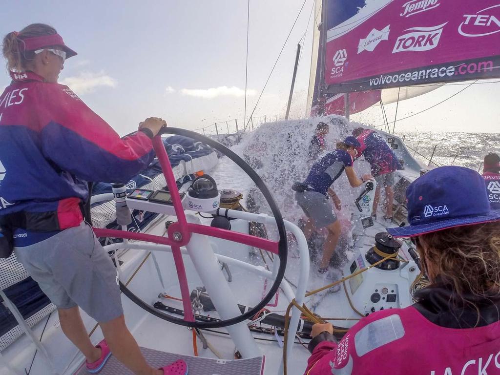 2014-15 Volvo Ocean Race. October 19, 2014. Leg 1 onboard Team SCA. Liz Wardley gets covered in a wave as the girls prepare to gybe near the Cape Verde Islands with Sam Davies at the helm. photo copyright Corinna Halloran / Team SCA taken at  and featuring the  class