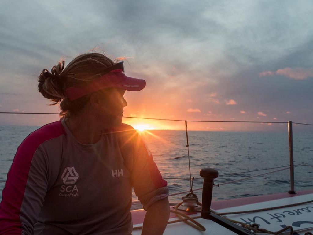 October 21, 2014.  Leg 1 onboard Team SCA. Sally Barkow takes time to admire the sunset. © Corinna Halloran / Team SCA