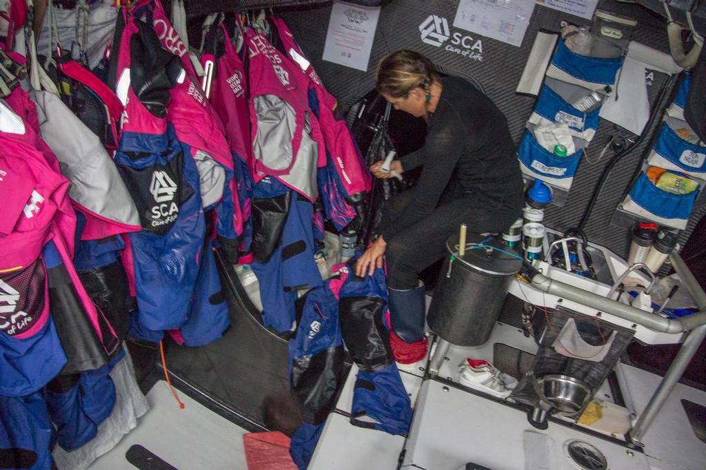 October, 2014. Leg 1 onboard Team SCA. SAm Davies empties her pockets after her watch. © Corinna Halloran / Team SCA