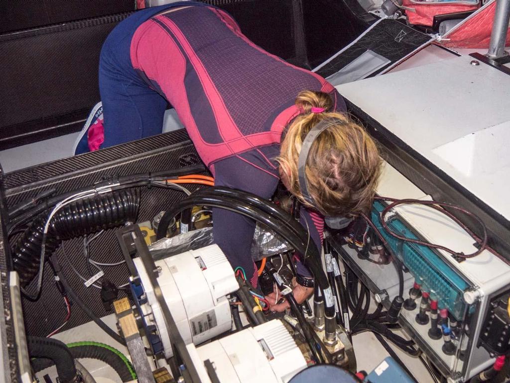 Liz Wardley works on finding the loose valve that is causing the keel to lose pressure. A loose valve can stop the pressure in the Hydraulic System preventing the keel from moving to counter-balance the boat when under sail. © Corinna Halloran / Team SCA