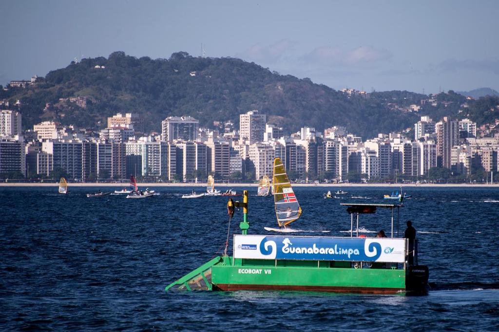 The ecoboat of Guanabara Limpa project collects debris in Guanabara Bay during a training session of 2014 Aquece Rio International Sailing Regatta. There were few complaints about floating debris in the 2015 Test Event. photo copyright Secretaria de Estado do Ambiente do Rio http://www.rj.gov.br taken at  and featuring the  class