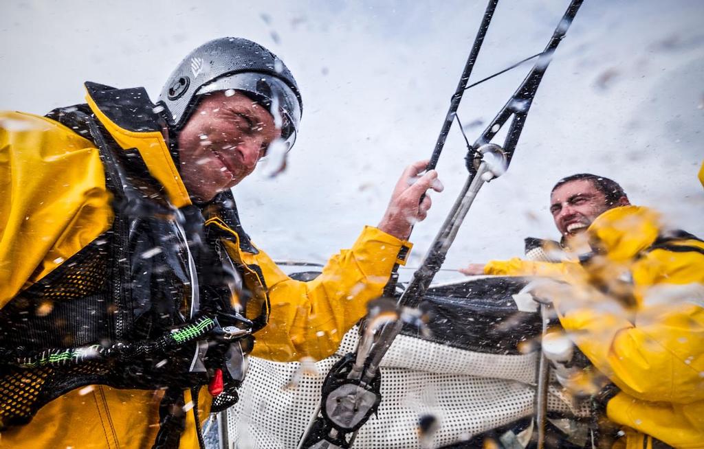 August 12, 2014. Round Britain Island Race Day 2 - OBR content Team Alvimedica: Alberto Bolzan laughs at the fact that Dave Swete can't get his helmet off after his driving stint during day two of the RORC's Round Britain and Ireland Race. ©  Amory Ross / Team Alvimedica