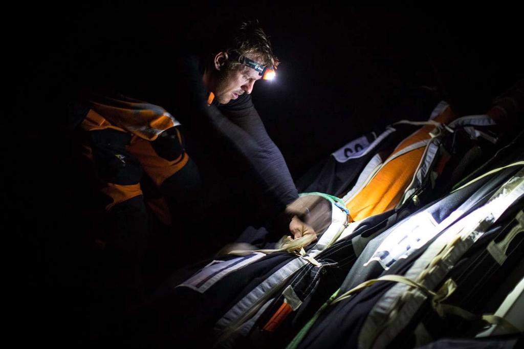 2014-15 Volvo Ocean Race. Leg 1 onboard Team Alvimedica. Day 4. It's a drag race to the Canary Islands with the fleet very compressed along the NW coast of Africa. Dave Swete tidies up the bow under headlamp for another busy night of variable winds and frequent sail changes. photo copyright  Amory Ross / Team Alvimedica taken at  and featuring the  class