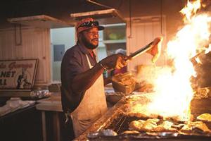 George cooks up  a flaming grilled marlin steak  at Oistin - Mount Gay Rum Round Barbados Race photo copyright The Galley Guys taken at  and featuring the  class