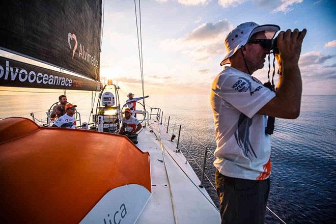 Leg 3 onboard Team Alvimedica. Day 12. A tough 48 hours in the Bay of Bengal of little-to-no wind and staggering heat and humidity; progress east is slow. Mark Towill, on the wheel, points to where he thinks he sees wind, while Will Oxley, with the binoculars, inspects closer. ©  Amory Ross / Team Alvimedica