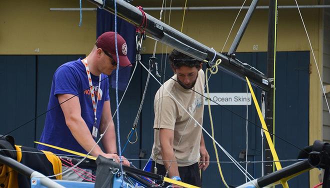 Ben McGrane and James Hughes (GBR) going through the last checks of the replacement mast and all boat equipment prior to the crucial start of Race 6. © Rhenny Cunningham