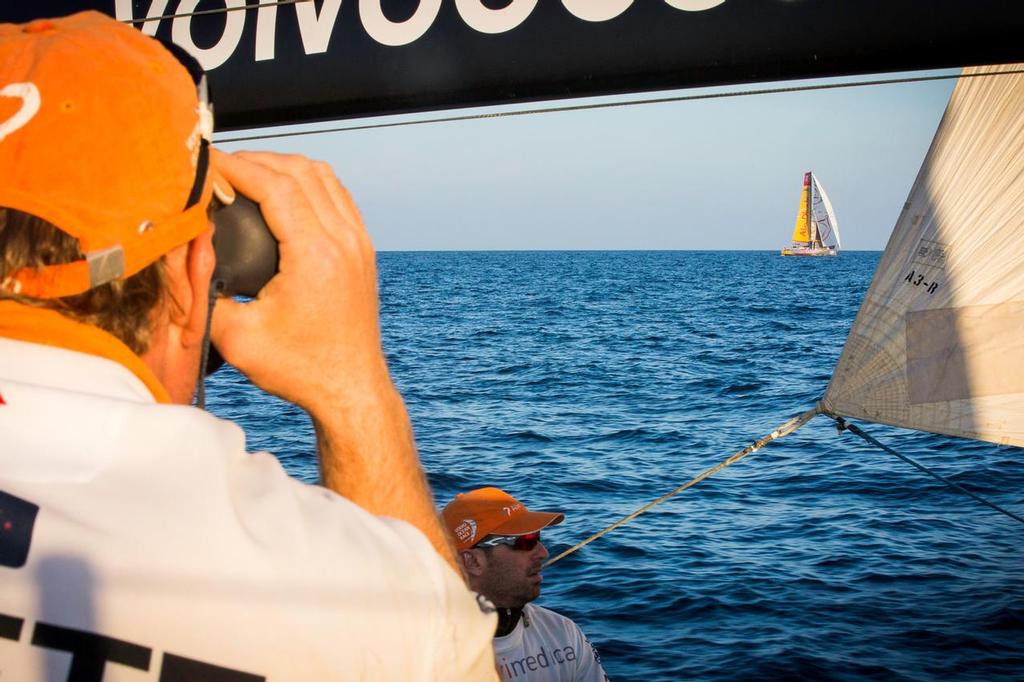January 7, 2015. Leg 3 onboard Team Alvimedica. Day 4. The push south towards a high pressure system continues and the conditions lighten overnight. Dongfeng Race Team has broken away but it’s close sailing for second place between Alvimedica, Abu Dhabi Ocean Racing, and Team Brunel. Dave Swete looks to Abu Dhabi Ocean Racing for any trim and technique tips the binoculars may provide, while Seb Marsset watches sail trim to leeward. ©  Amory Ross / Team Alvimedica