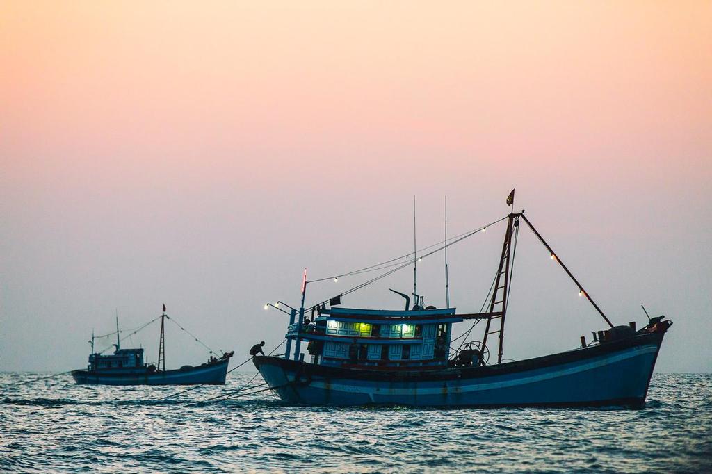 January 25, 2015. Day 22 of Leg 3 to Sanya, onboard Team Alvimedica. Through the fishing grounds off the Vietnam coast, it's a 300 mile drag race to Sanya with three competitors still in sight. Two Vietnamese fishing trawlers towing their nets at sunrise. photo copyright  Amory Ross / Team Alvimedica taken at  and featuring the  class