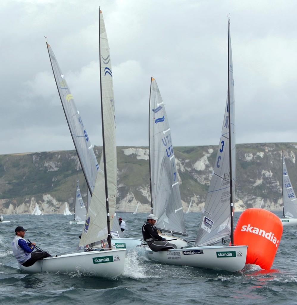 Ben Ainslie, Right, from Great Britain, hits the a turning mark whilst racing in the racing in the Finn class and has to do a 360 1/4  penalty, on day 2 of the Skandia Sail for Gold Regatta, in Weymouth and Portland, the 2012 Olympic venue. The regatta runs from 6-11 June 2011, bringing together the worldÕs top Olympic and Paralympic class sailors. photo copyright onEdition http://www.onEdition.com taken at  and featuring the  class