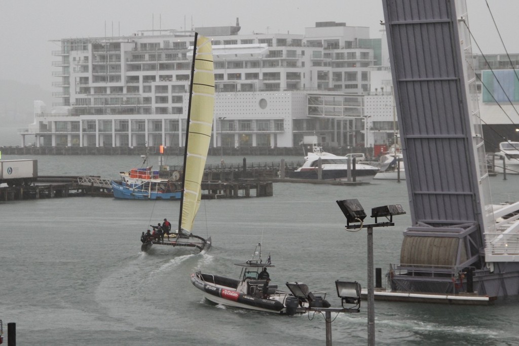 Emirates Team NZ’s SL-33 begins to fly a hull as she leaves the team’s base in the Viaduct harbour and heads off for a training session in the mid-winter murk. photo copyright Richard Gladwell www.photosport.co.nz taken at  and featuring the  class