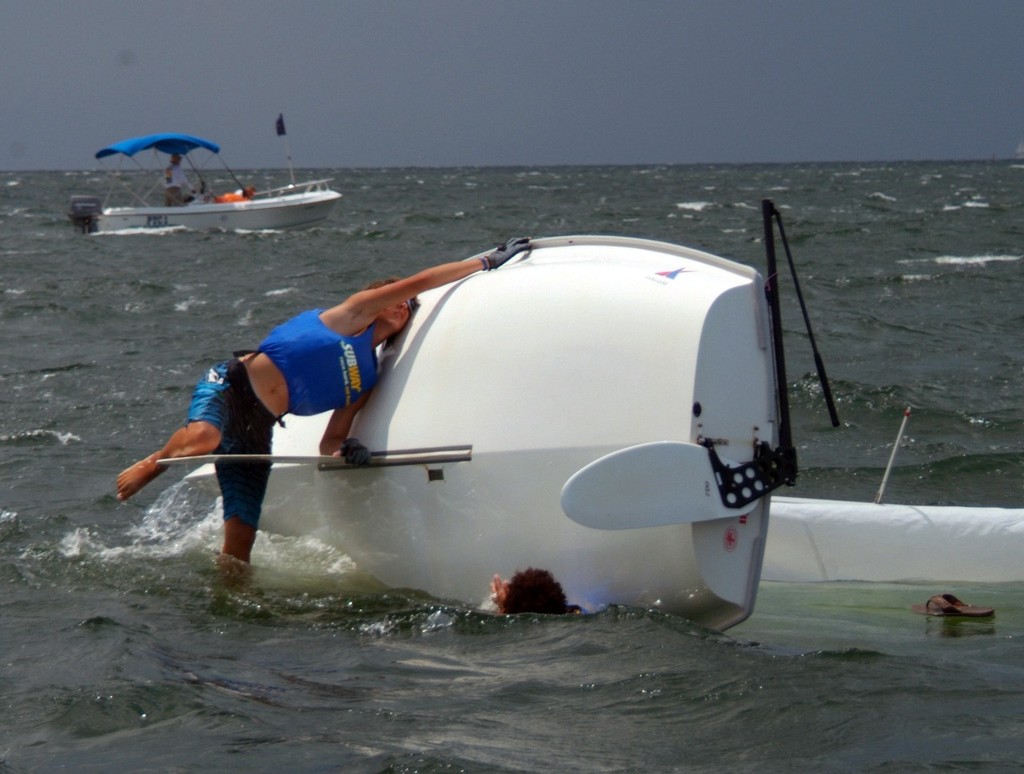 Keenan Madewell, on the centerboard, and Ameer Elzawahry work on righting 420 sailboat #67 after capsizing in Pensacola Bay after Sunday's only race. This was the final race of the SUBWAY USA Junior Olympic Festival and Independence Day Regatta. A BP safety boat stands by to assist if necessary.

 photo copyright Talbot Wilson taken at  and featuring the  class