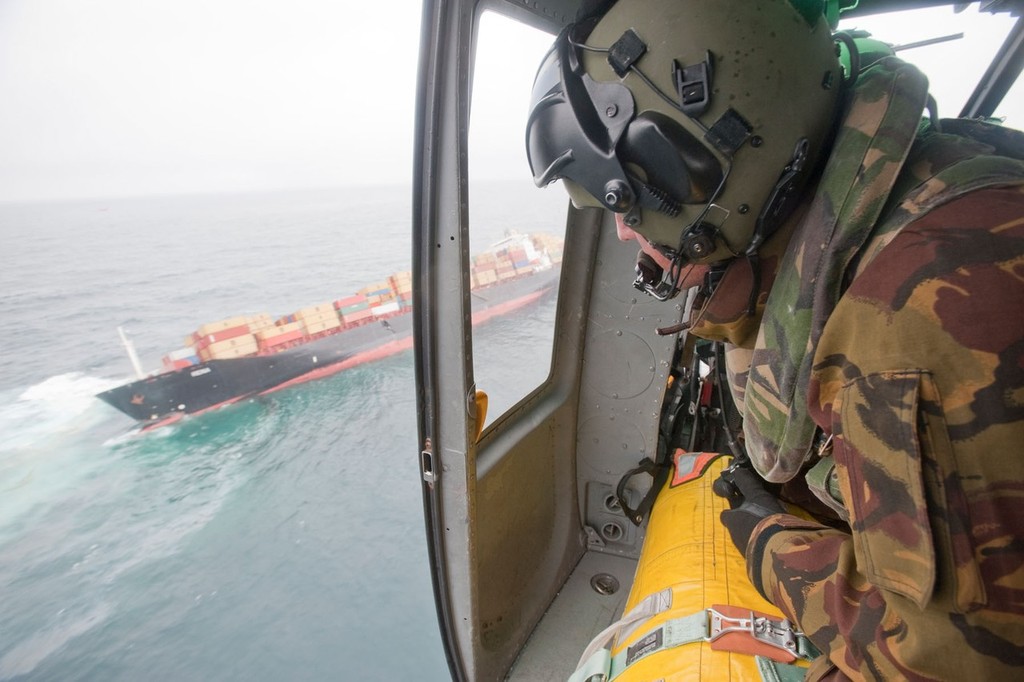Helicopter Crewman, Sergeant Karl Borck watches out as an Air Force Iroquois flys over grounded vessel Rena  - Rena Disaster - 13 October 2011 © New Zealand Defence Force