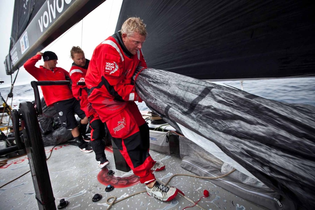 Tony Mutter, Michi Mueller, and Tom Addis banding a sail on deck during one of the many lulls in action. PUMA Ocean Racing powered by BERG during leg 2 of the Volvo Ocean Race 2011-12, from Cape Town, South Africa to Abu Dhabi, UAE. (Credit: Amory Ross/PUMA Ocean Racing/Volvo Ocean Race) photo copyright Amory Ross/Puma Ocean Racing/Volvo Ocean Race http://www.puma.com/sailing taken at  and featuring the  class