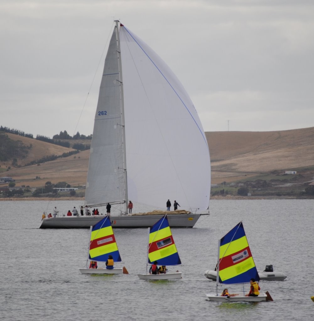 Helsal III sails slowly the down the Derwent past a fleet of Optis from Sandy Bay Sailing Club. photo copyright Rob Cruse taken at  and featuring the  class