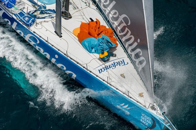 Team Telefonica, pulling down a sail, at the start of leg 8 from Lisbon, Portugal to Lorient, France, during the Volvo Ocean Race 2011-12.  © Paul Todd/Volvo Ocean Race http://www.volvooceanrace.com