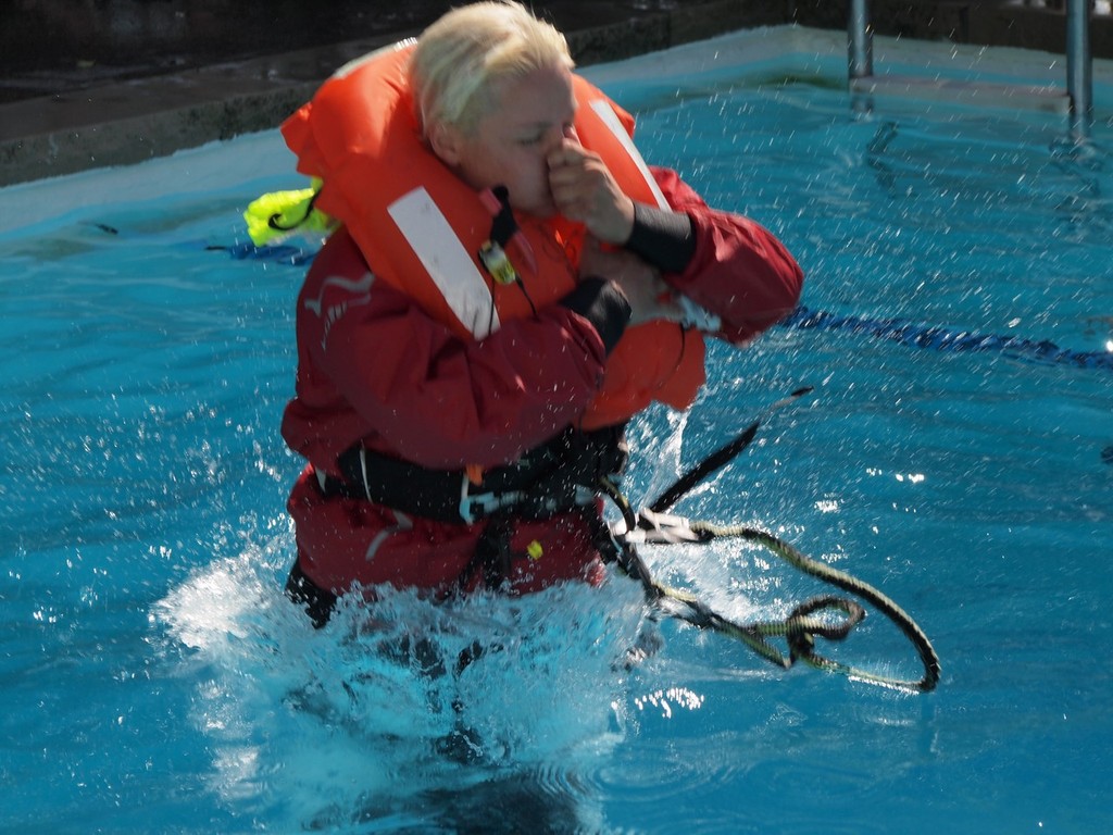 One Girl's Ocean Challenge Diane Reid shows the proper way to enter the water, one arm holding her PFD down while protecting her face photo copyright Greg Nicoll taken at  and featuring the  class