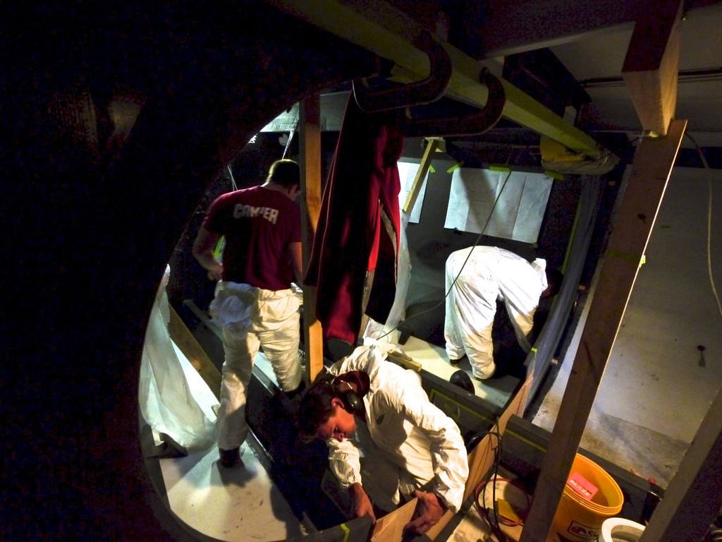 The team boatbuilders hard at work installing the new bulkhead onboard CAMPER with Emirates Team New Zealand during leg 5 of the Volvo Ocean Race 2011-12, from Auckland, New Zealand to Itajai, Brazil. (Credit: Hamish Hooper/CAMPER ETNZ/Volvo Ocean Race) photo copyright Hamish Hooper/Camper ETNZ/Volvo Ocean Race taken at  and featuring the  class