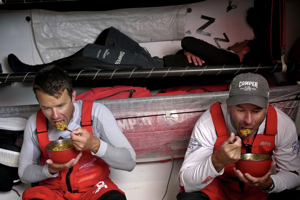 Nick Burridge and Rob Salthouse eat lunch after coming off watch right beside Roberto Bermudez de Castro sleeping onboard CAMPER with Emirates Team New Zealand during leg 7 of the Volvo Ocean Race 2011-12, from Miami, USA to Lisbon, Portugal. (Credit: Hamish Hooper/CAMPER ETNZ/Volvo Ocean Race) photo copyright Hamish Hooper/Camper ETNZ/Volvo Ocean Race taken at  and featuring the  class