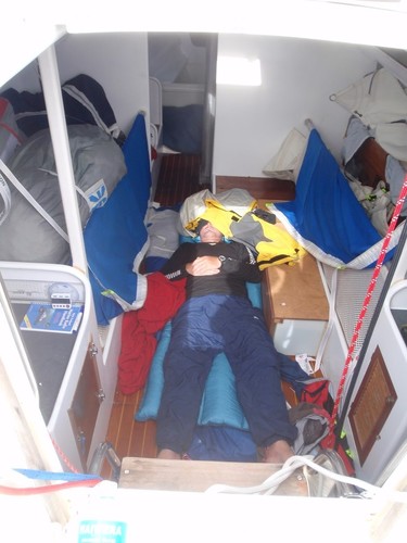 Life downstairs,  Rob sleeps on the floor, with sails stacked in the saloon bunks - 2012 Two Handed Round New Zealand Race - Expedition Coppelia © SW