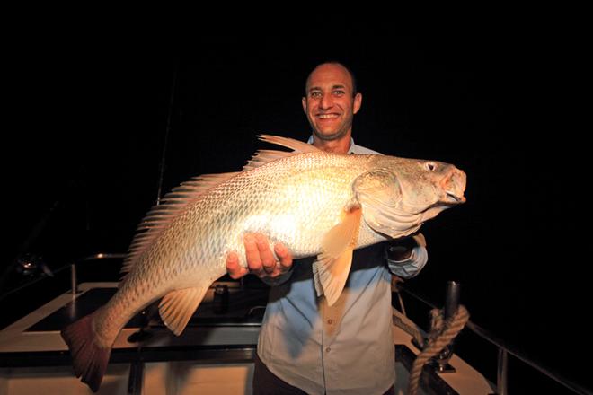 Ryan displaying a solid jewfish during the night. © Jarrod Day