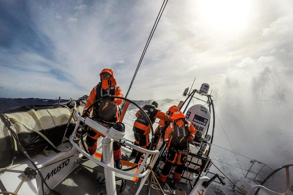March 24, 2015. Leg 5 to Itajai onboard Team Alvimedica. Day 6. A late night gybe set off a wild day of true Southern Ocean sailing as the temps dropped and the wind and waves built with an approaching low pressure system and accompanying cold front. Ryan Houston driving downwind in heavy winds. ©  Amory Ross / Team Alvimedica