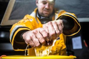 Onboard Abu Dhabi Ocean Racing - Daryl Wislang squeezes water out of a sponge after cleaning out the engine bilge from sea water - Leg five to Itajai - Volvo Ocean Race 2015 photo copyright Matt Knighton/Abu Dhabi Ocean Racing taken at  and featuring the  class
