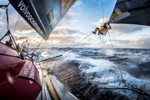 Onboard Abu Dhabi Ocean Racing - Luke Parko Parkinson swings out over the southern ocean to tie a changing sheet on the FRO at sunset - Leg five to Itajai -  Volvo Ocean Race 2015 photo copyright Matt Knighton/Abu Dhabi Ocean Racing taken at  and featuring the  class