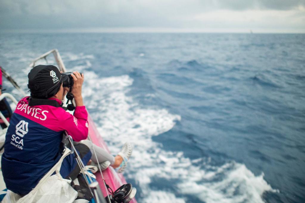 April 20, 2015. Leg 6 to Newport onboard Team SCA. Day 1. Sam Davies watches Dongfeng Race Team on the horizon with the binoculars. © Corinna Halloran / Team SCA