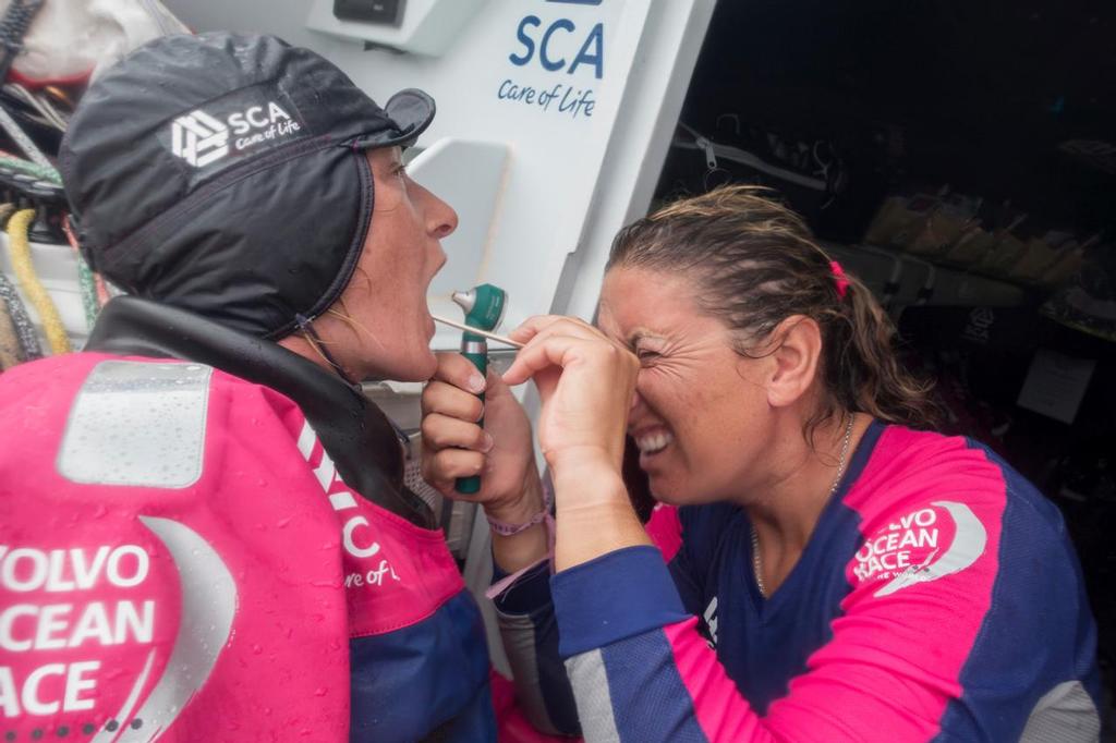 April 22, 2015. Leg 6 to Newport onboard Team SCA. Day 3. Dee Caffari checks out Abby Ehler's throat; Dee is one of the on board medics for leg 6. © Corinna Halloran / Team SCA