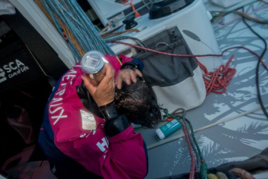 April 22, 2015. Leg 6 to Newport onboard Team SCA. Day 3. Justine Mettraux takes five to wash her hair after the last two days of constant salt spray. © Corinna Halloran / Team SCA
