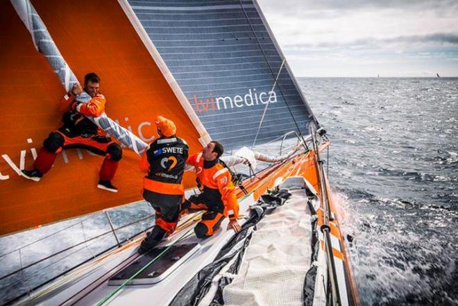 Nick leaps onto the furled sail in an attempt to bring it down to windward, while Dave Swete and Seb Marsset pull from below - Volvo Ocean Race ©  Amory Ross / Team Alvimedica