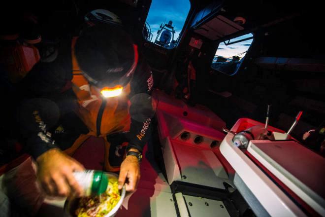 Leg 7 to Lisbon onboard Team Alvimedica. Day 03. Charlie Enright douses his Pasta Primavera in parmesan cheese before a late night meal. Approaching the southern limits of the Greenland Ice Exclusion Zone the fleet compresses further,all six within sight of each other. - Volvo Ocean Race 2015 ©  Amory Ross / Team Alvimedica