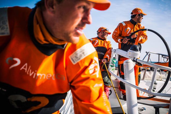  Leg 7 to Lisbon onboard Team Alvimedica. Day 05. Dave Swete (L),Ryan Houston (M),and Mark Towill (R) stare in unison at Abu Dhabi to the west,executing a peel from their Masthead Code Zero to their A3 spinnaker. The racing has been so close that the crew spend much of their time looking at other boats,rather than focusing on sailing their own. The drag race northeast towards the eastern edge of the ice exclusion zone continues with the front five all still within a few miles of each other. ©  Amory Ross / Team Alvimedica