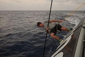 Leg 6 to Newport onboard Team Brunel. Day 12. Rokas Milevicius tries to get weed from the keel with a sail batten,the sargasso weed is still playing a big roll in the drag race. photo copyright Stefan Coppers/Team Brunel taken at  and featuring the  class
