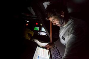 Onboard Abu Dhabi Ocean Racing – Roberto Bermudez 'Chuny' reads an email from his family in the darkness below just after the sun goes down on deck - Leg six to Newport – Volvo Ocean Race photo copyright Matt Knighton/Abu Dhabi Ocean Racing taken at  and featuring the  class
