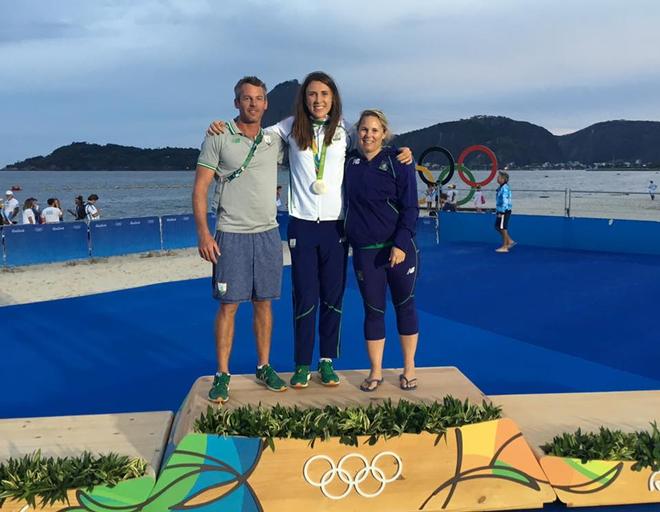 Olympic Silver Medalist Annalise Murphy, Sara Winther (NZL) and trainer Rory Fitzpatrick pose on the medal podium in Rio de Janeiro. © SW